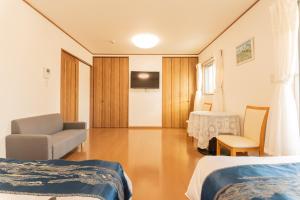 a room with two beds and a chair and a tv at 九洲別苑 in Osaka +95 photos