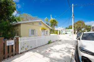 een huis met een wit hek en een auto voor de deur bij Prime Downtown Location - Truman Little Cozy Cottage in Key West