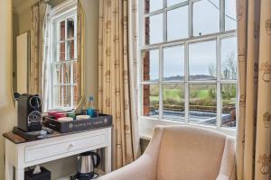 亨利昂泰晤士Flower Pot Hotel的带椅子和窗户的客厅