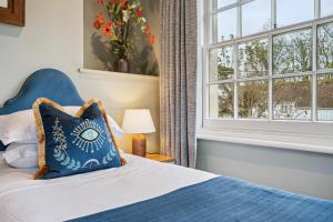 亨利昂泰晤士Flower Pot Hotel的带蓝色床和窗户的卧室