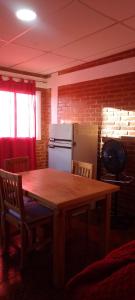 a kitchen with a wooden table and a refrigerator at Bella Fefi in Villa Cura Brochero +1 photo