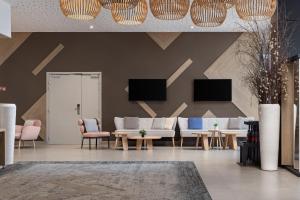 a lobby with couches and tables and chairs at Hilton Garden Inn Bordeaux Centre in Bordeaux