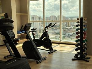 a gym with two exercise bikes in front of a window at Promenade Soho Campos dos Goytacazes in Campos dos Goytacazes