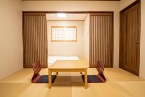 a room with a table and two chairs and a bed at 九洲別苑 in Osaka