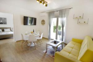 a living room with a yellow couch and a table at Relaxing holiday home with shared pool in Čepljani