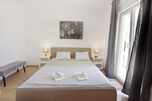 a bedroom with a bed with two towels on it at Relaxing holiday home with shared pool in Čepljani +67 photos