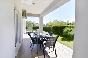 a dining room with a table and chairs on a patio at Relaxing holiday home with shared pool in Čepljani