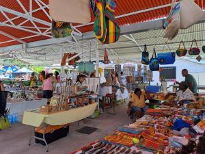 a group of people in a market selling items at Le Paradis bleu in Sainte-Anne