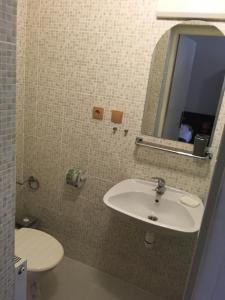 a bathroom with a sink and a toilet and a mirror at HARRYS City Motel in Komárno