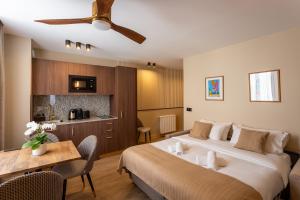 a hotel room with two beds and a table and a kitchen at Sol Hotel - Saint Mandé in Saint-Mandé
