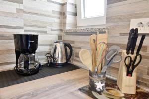 a kitchen counter with a coffee maker and utensils at Modern holiday home with shared pool in Čepljani
