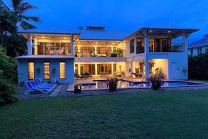 a large house with a pool in front of it at BIG Beach House Tranquility in Kewarra Beach