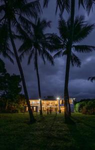 a building with two palm trees in front of it at BIG Beach House Tranquility in Kewarra Beach