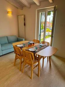 a wooden table and chairs in a living room at -La Bella Ameglia- Private Parking in Luni