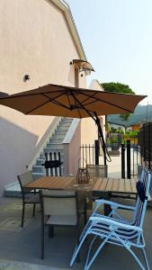 a table and chairs with an umbrella on a patio at -La Bella Ameglia- Private Parking in Luni