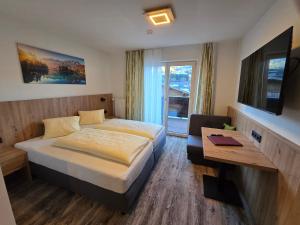 una habitación de hotel con una cama y una mesa en Wellness Pension Hollaus, en Kirchberg in Tirol