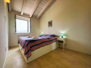a bedroom with a bed with a night stand and a window at -La Bella Ameglia- Private Parking in Luni