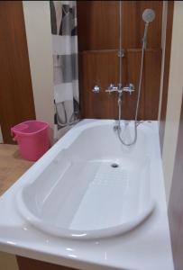 een witte wastafel met een douche in de badkamer bij Jacqueline houseboat in Srinagar