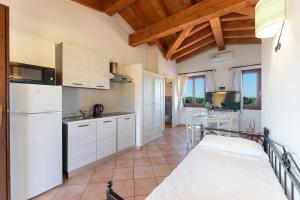 een keuken met een witte koelkast en een tafel bij Cozy accommodation with shared pool in Vignola Mare