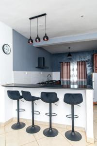 een keuken met een aanrecht met vier barkrukken bij Maison avec Jardin à la Pyrot in Diego Suarez