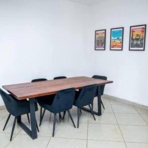 een houten tafel met stoelen in een kamer bij Maison avec Jardin à la Pyrot in Diego Suarez