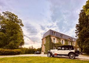 an old car parked in front of a house at Château de Belleaucourt in Coulommes-la-Montagne