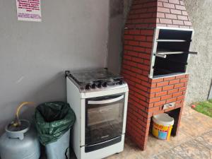 a brick oven sitting next to a brick wall at Casa com piscina, aconchegante, aceita pet in Cotia