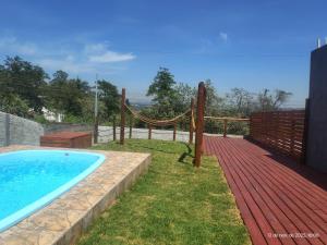 a swimming pool with a hammock next to a fence at Casa com piscina,tipo kitnet, próximo ao Centro in Cotia