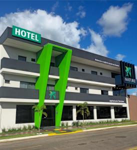 博尼图Nature Bonito Hotel的一家前面有绿色标志的酒店