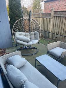 a patio with two chairs and a swing with pillows at Modern 7 Bedroom Masterpiece on Portage Sleeps 16 in Niagara Falls