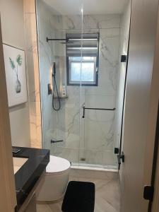 a bathroom with a shower with a toilet and a sink at Modern 7 Bedroom Masterpiece on Portage Sleeps 16 in Niagara Falls