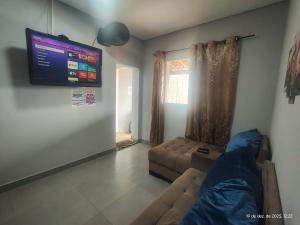 a living room with a couch and a flat screen tv at Casa com piscina,tipo kitnet, próximo ao Centro in Cotia