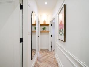 a hallway with white walls and a mirror at Calico at The Heim Residences in Manchester
