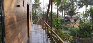 戈卡尔纳Prakruti Home stay In Beach Side AC Room的通往棕榈树房屋的木制走道 更多83张照片