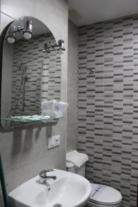 a bathroom with a sink and a toilet and a mirror at Apartamentos Bolonia Paraiso in Bolonia