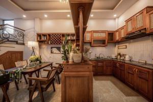 a kitchen with wooden cabinets and a table with chairs at Le'Mon in Da Lat