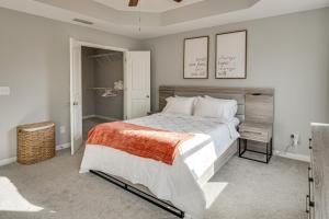 een slaapkamer met een groot bed en twee foto's aan de muur bij WFH Setup, Fenced Yard! Spacious Spring Hill Stay in Kedron