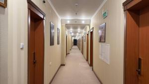 乌尔根奇Khorezm Palace Hotel的走廊上设有木门和长走廊的走廊