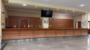 a lobby with a waiting area with a tv on the wall at Khorezm Palace Hotel in Urganch