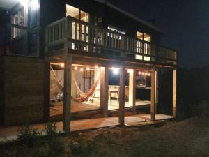 una casa con un'amaca di fronte ad essa di notte di ClariCri a La Pedrera