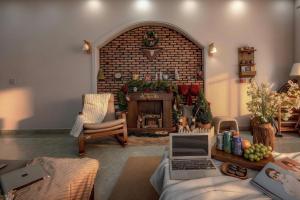 a living room with a fireplace and a laptop on a couch at Le'Mon in Da Lat