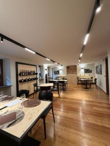 ein Zimmer mit Tischen, Stühlen und Weinflaschen in der Unterkunft La Cantina del Sole in Pontboset
