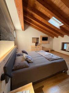 ein Schlafzimmer mit großem Bett und Holzdecken in der Unterkunft La Cantina del Sole in Pontboset