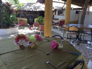 a table with a green table cloth and flowers on it at Campement Le Cormoran in Ndangane