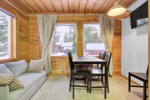 a living room with a table and a couch at Pyhäkoti D - 30 Meters From the Slopes in Pyhätunturi