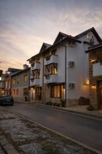 een gebouw in een straat met een auto voor de deur bij Хотел Ривърсайд Анекс in Bansko
