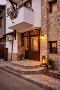 een gebouw met een houten deur en trap voor de deur bij Хотел Ривърсайд Анекс in Bansko +3 foto's