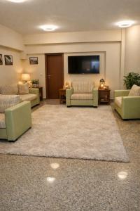 een grote woonkamer met banken en een flatscreen-tv bij Хотел Ривърсайд Анекс in Bansko