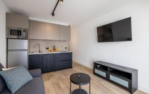 a living room with a couch and a kitchen at Cozy Apartment In Potomje With Lake View in Potomje