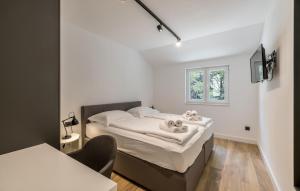a small bedroom with a bed and a window at Cozy Apartment In Potomje With Lake View in Potomje